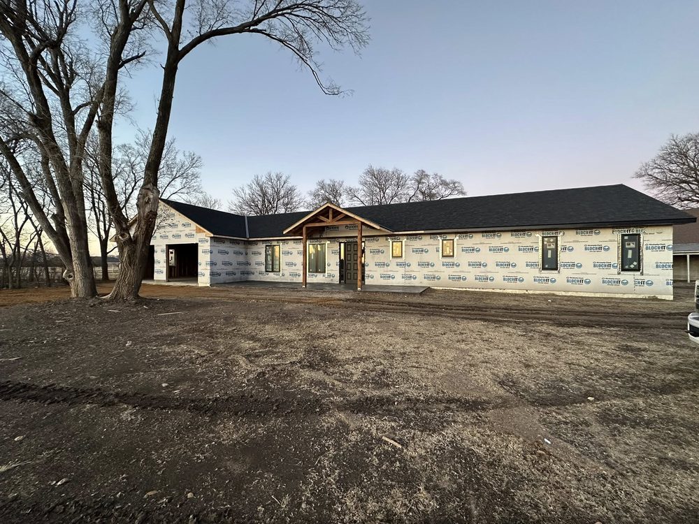 Wide ranch home under construction at dusk