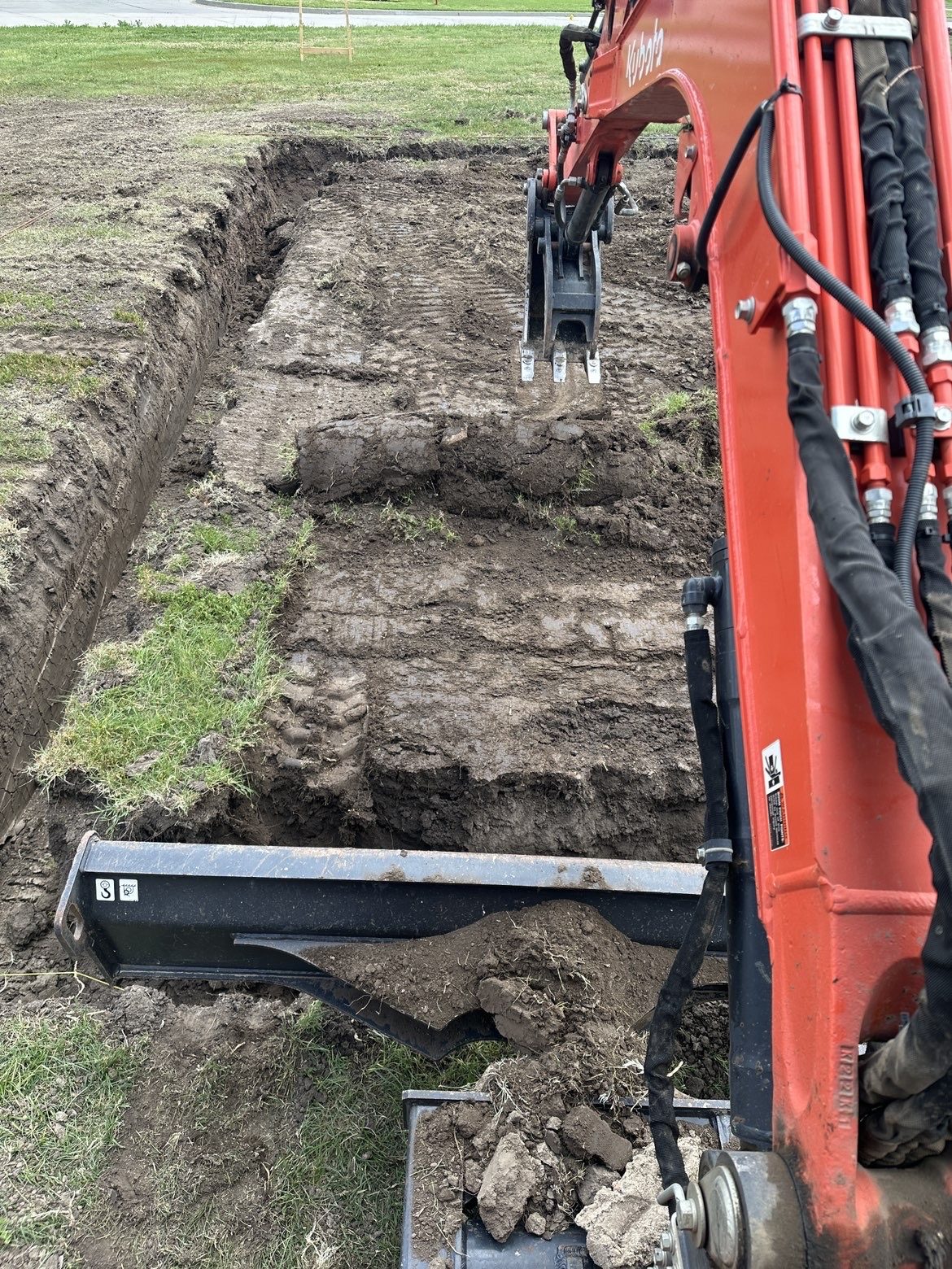 Excavator working on a rural Kansas building site during BlackRidge Contracting site prep